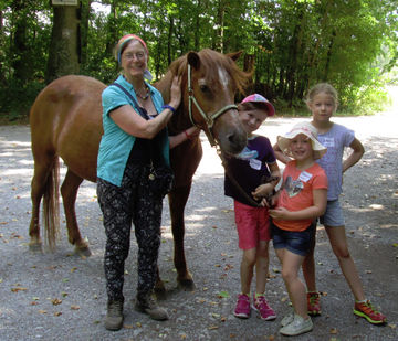 Das Foto zeigt ein Pony mit Kindern und Betreuerin.